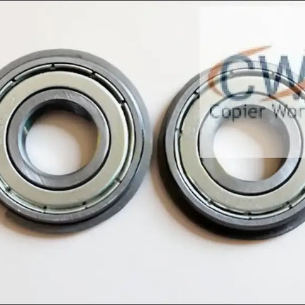 Two Canon IR5075 LOWER BERING metal ball bearings, each with a central hole, identical circular shapes, and a smooth metallic finish, are placed side by side on a white surface.